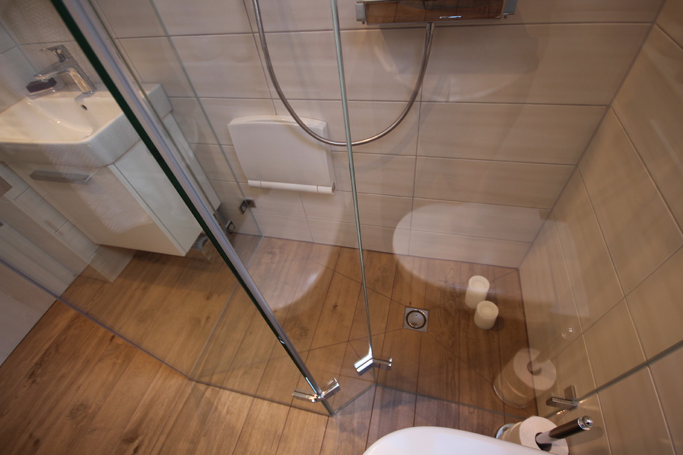 Exempel på ett litet modernt badrum med dusch, med vita skåp, en kantlös dusch, en vägghängd toalettstol, brun kakel, porslinskakel, beige väggar, klinkergolv i porslin och ett avlångt handfat