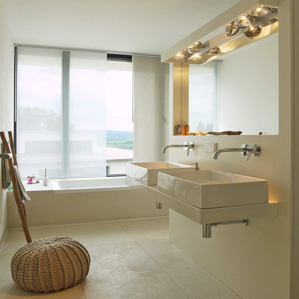 Foto på ett mellanstort funkis badrum, med ett fristående handfat, beige kakel, porslinskakel, vita väggar, klinkergolv i porslin och ett platsbyggt badkar