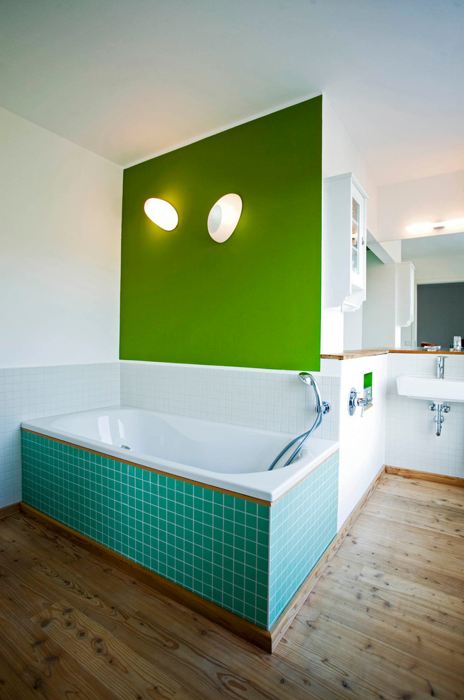 Стильный дизайн: большая ванная комната в современном стиле с накладной ванной, белой плиткой, зелеными стенами, паркетным полом среднего тона и подвесной раковиной - последний тренд