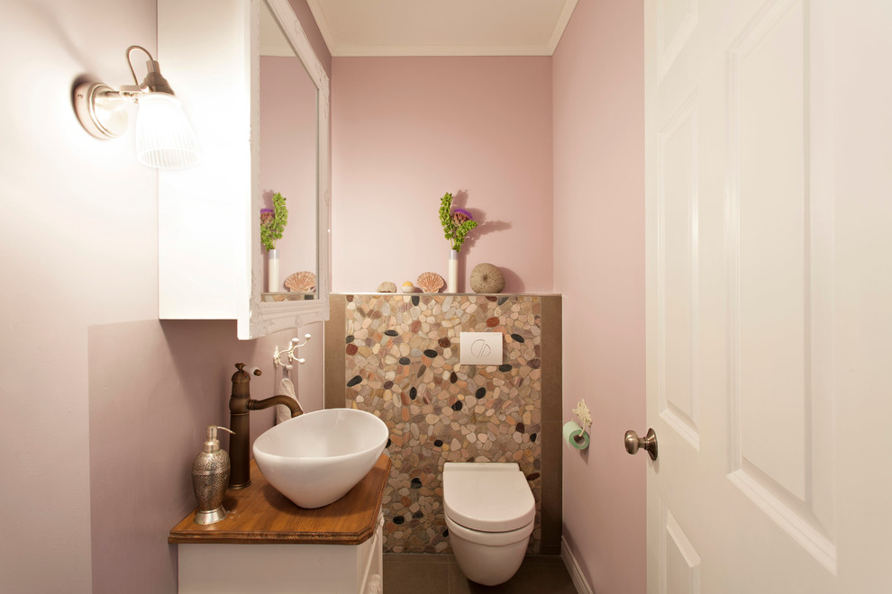 Пример оригинального дизайна: маленькая ванная комната в классическом стиле с настольной раковиной, белыми фасадами, столешницей из дерева, инсталляцией и розовыми стенами для на участке и в саду