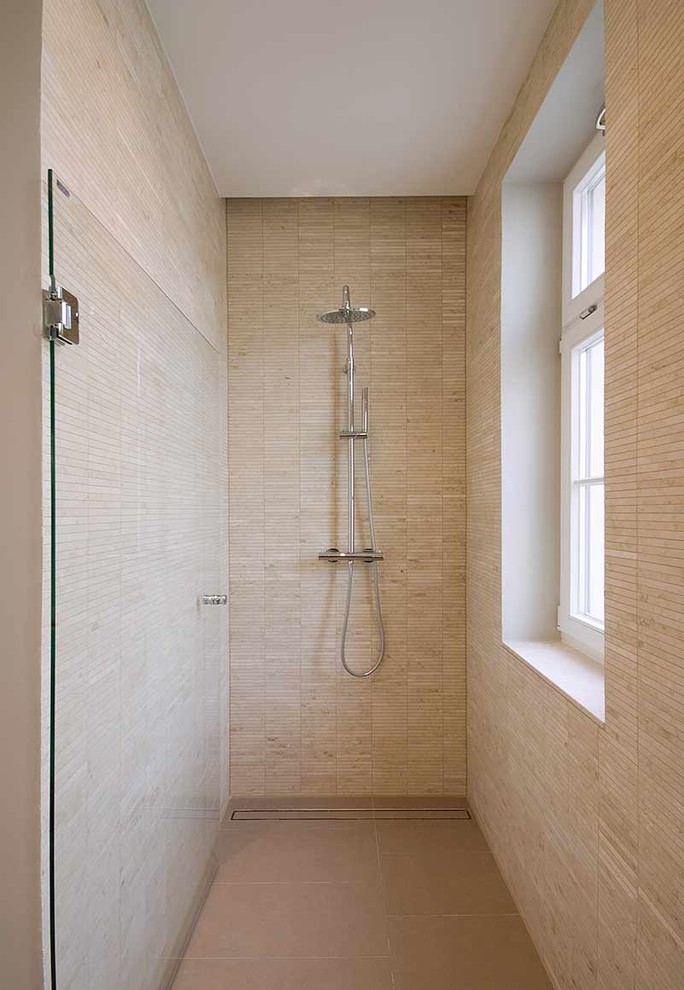 Modern inredning av ett badrum, med en dusch i en alkov, beige kakel, stickkakel och beige väggar