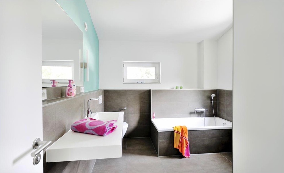 Mittelgroßes Modernes Badezimmer En Suite mit Einbaubadewanne, braunen Fliesen, weißer Wandfarbe, Keramikboden, Waschtischkonsole und braunem Boden in München