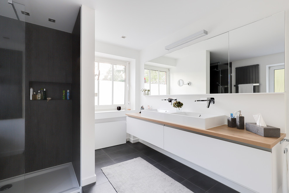 Design ideas for a large contemporary ensuite bathroom in Dusseldorf with white cabinets, a built-in shower, a vessel sink, an open shower, flat-panel cabinets, white walls, wooden worktops, black floors and brown worktops.