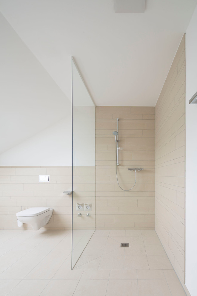 Ispirazione per una grande stanza da bagno minimalista con piastrelle beige, piastrelle in pietra, pavimento in travertino, doccia aperta, WC sospeso, pareti bianche e doccia aperta