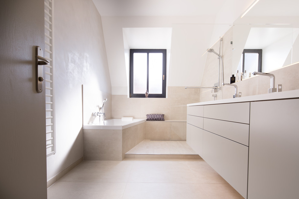 Свежая идея для дизайна: огромная ванная комната в современном стиле с плоскими фасадами, бежевыми фасадами, угловой ванной, угловым душем, бежевой плиткой, белыми стенами, врезной раковиной, столешницей из искусственного камня, бежевым полом, открытым душем и белой столешницей - отличное фото интерьера