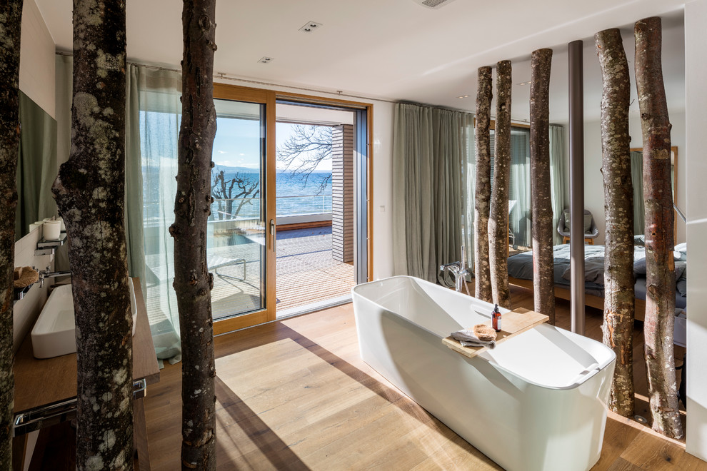 Свежая идея для дизайна: главная ванная комната среднего размера в современном стиле с отдельно стоящей ванной, белыми стенами, светлым паркетным полом и настольной раковиной - отличное фото интерьера