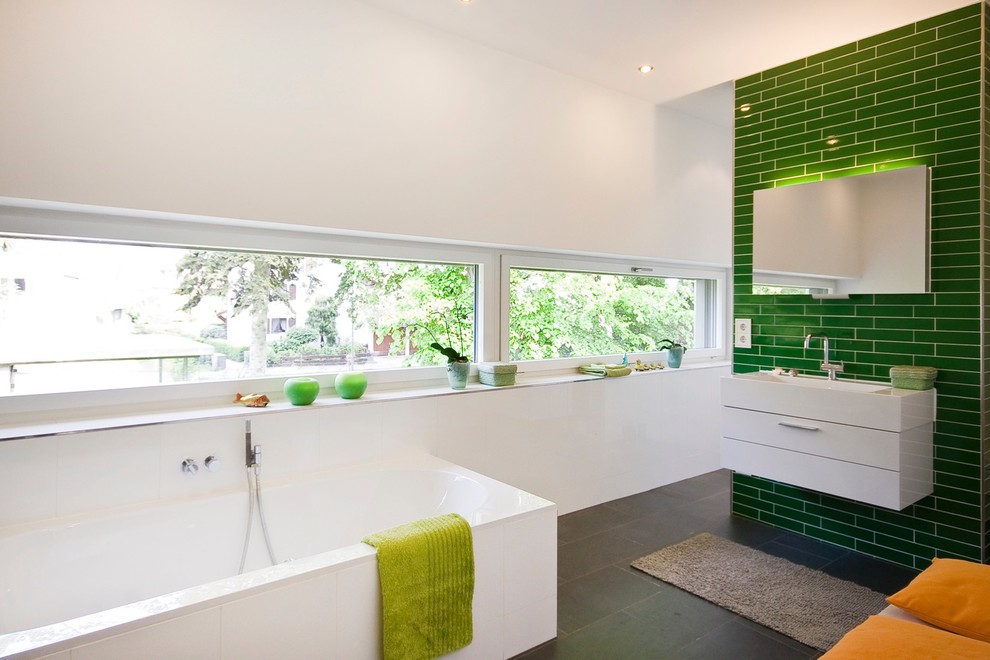 Idée de décoration pour une salle de bain design de taille moyenne avec un mur vert et une grande vasque.