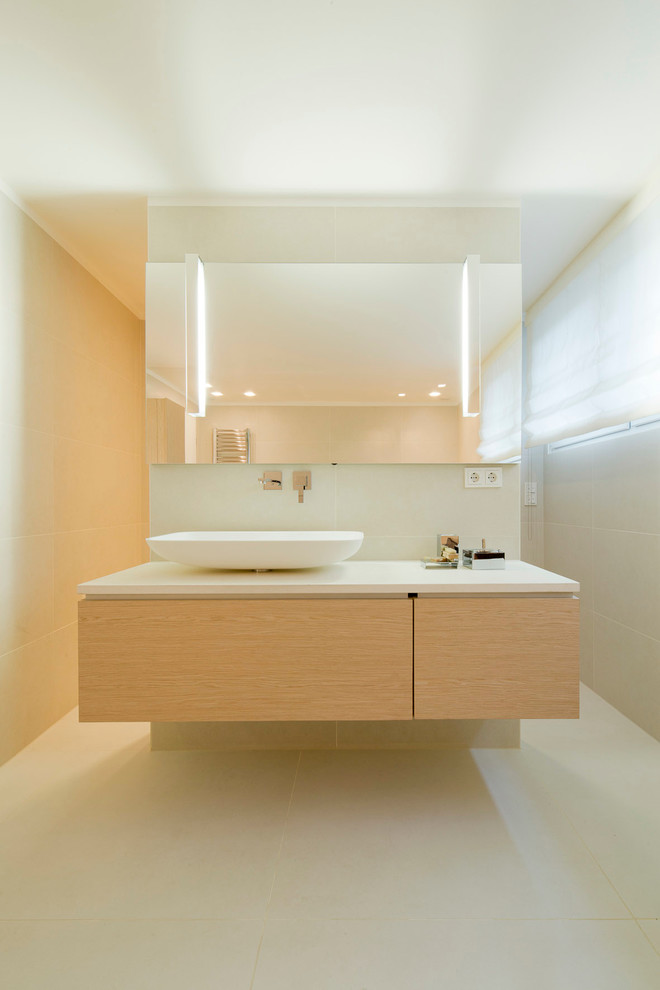 Cette photo montre une salle de bain tendance en bois clair de taille moyenne avec une vasque, un placard à porte plane, un carrelage beige et un mur beige.
