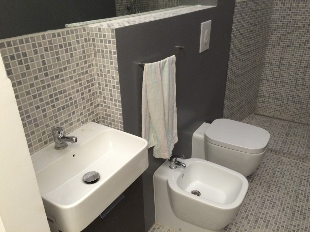 Cette image montre une petite salle d'eau design avec une douche ouverte, un bidet, un carrelage gris, des carreaux de céramique, un mur gris, un sol en carrelage de terre cuite et un plan vasque.