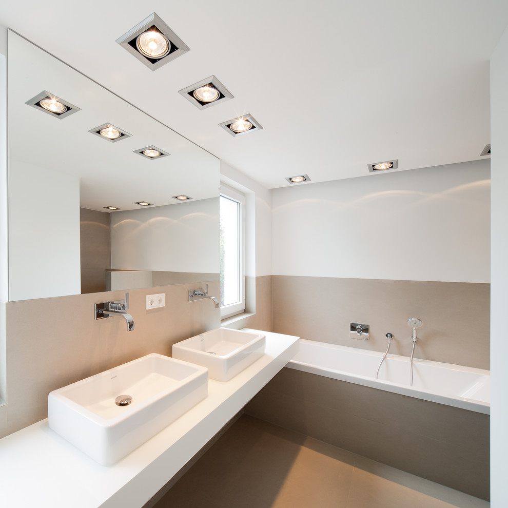 Стильный дизайн: большая ванная комната в современном стиле с накладной ванной, белыми стенами, настольной раковиной, бежевой плиткой и окном - последний тренд
