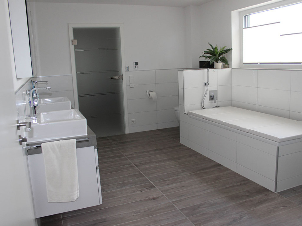 Großes Modernes Badezimmer mit weißen Schränken, weißen Fliesen, weißer Waschtischplatte und Doppelwaschbecken in Stuttgart