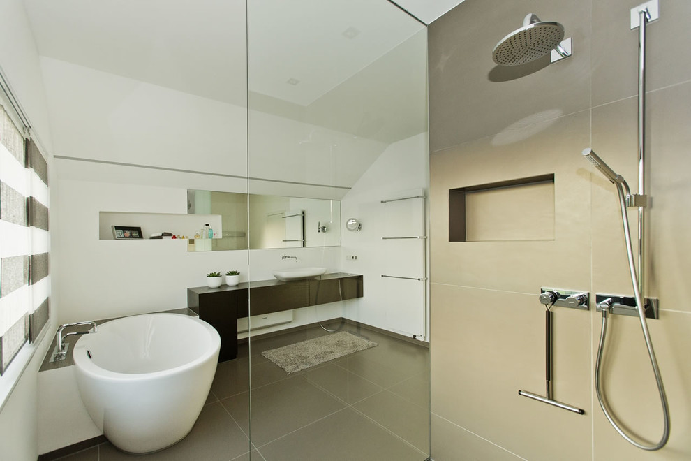 На фото: ванная комната среднего размера в современном стиле с отдельно стоящей ванной, белыми стенами, настольной раковиной и открытым душем
