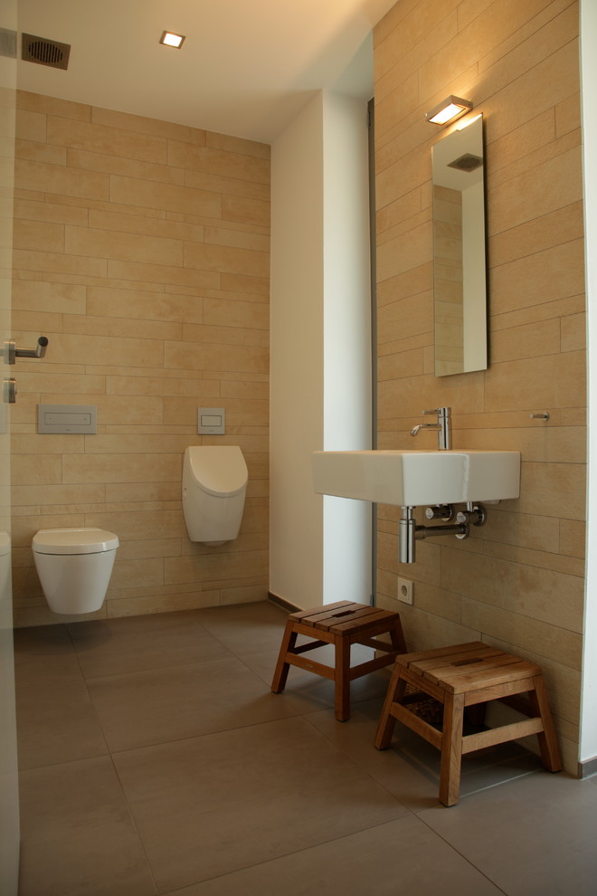 Mittelgroßes Modernes Badezimmer mit Wandtoilette mit Spülkasten, beigen Fliesen, weißer Wandfarbe, Wandwaschbecken und braunem Boden in Dortmund