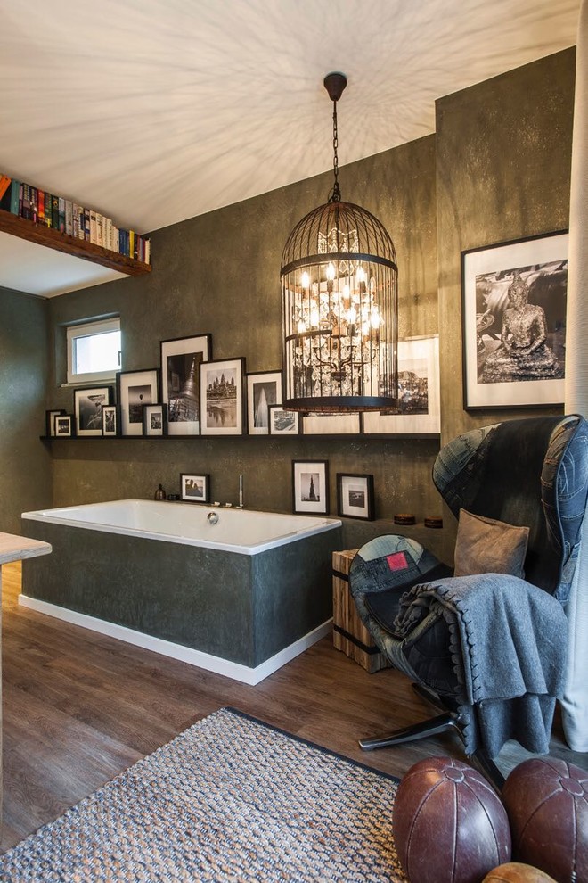 Modelo de cuarto de baño tradicional de tamaño medio con bañera exenta, paredes negras, suelo de madera en tonos medios, aseo y ducha y suelo marrón