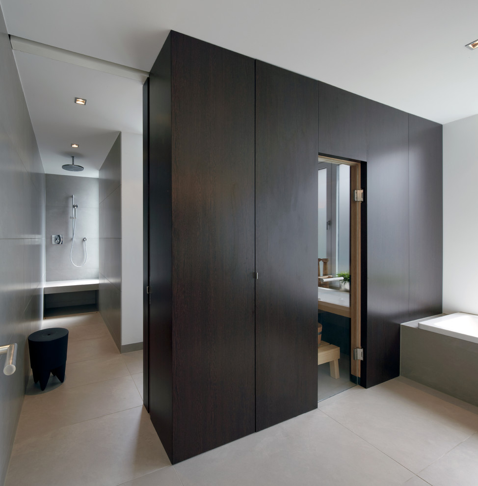 Inspiration för mellanstora moderna en-suite badrum, med släta luckor, skåp i mörkt trä, ett platsbyggt badkar, en kantlös dusch, en vägghängd toalettstol, grå kakel, keramikplattor, grå väggar, klinkergolv i keramik, grått golv och med dusch som är öppen