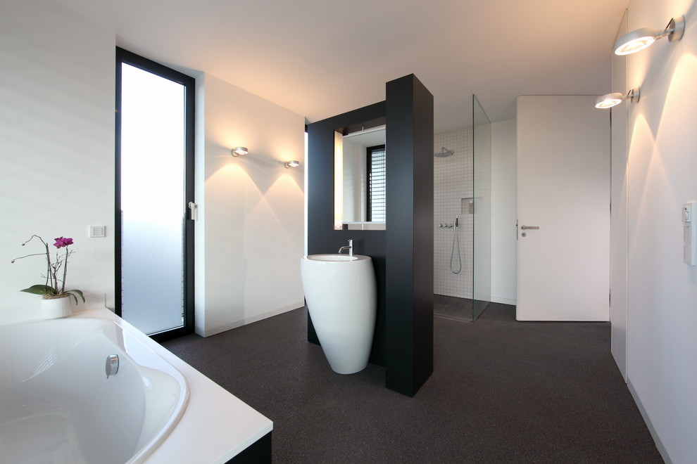 This is an example of a large contemporary ensuite bathroom in Munich with a built-in bath, a built-in shower, white tiles, white walls and a pedestal sink.