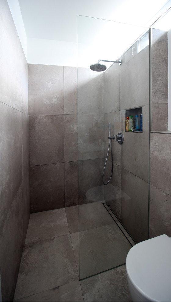 Foto de cuarto de baño infantil contemporáneo con ducha a ras de suelo, sanitario de pared, baldosas y/o azulejos grises, paredes grises y suelo de baldosas de cerámica