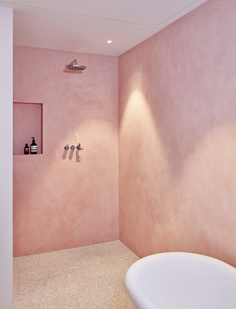 Inspiration for a large contemporary shower room bathroom in Munich with louvered cabinets, white cabinets, a freestanding bath, a built-in shower, a wall mounted toilet, pink walls, terrazzo flooring, a vessel sink, wooden worktops, grey floors, an open shower and black worktops.
