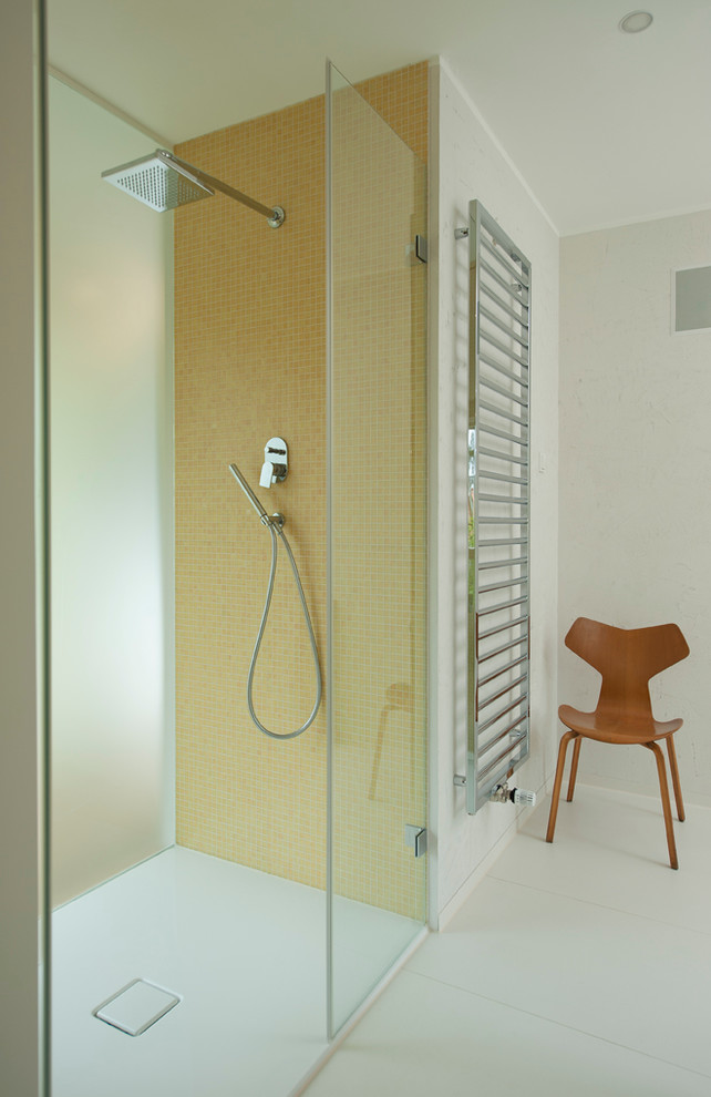 Foto på ett funkis badrum, med en kantlös dusch, gul kakel, mosaik och vita väggar
