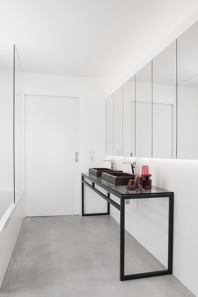 Esempio di una stanza da bagno minimalista di medie dimensioni con pareti bianche, pavimento in cemento, lavabo a bacinella e pavimento grigio
