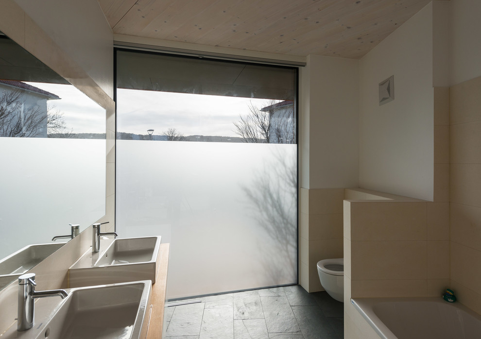 Идея дизайна: огромная ванная комната в современном стиле с накладной ванной, раздельным унитазом и настольной раковиной