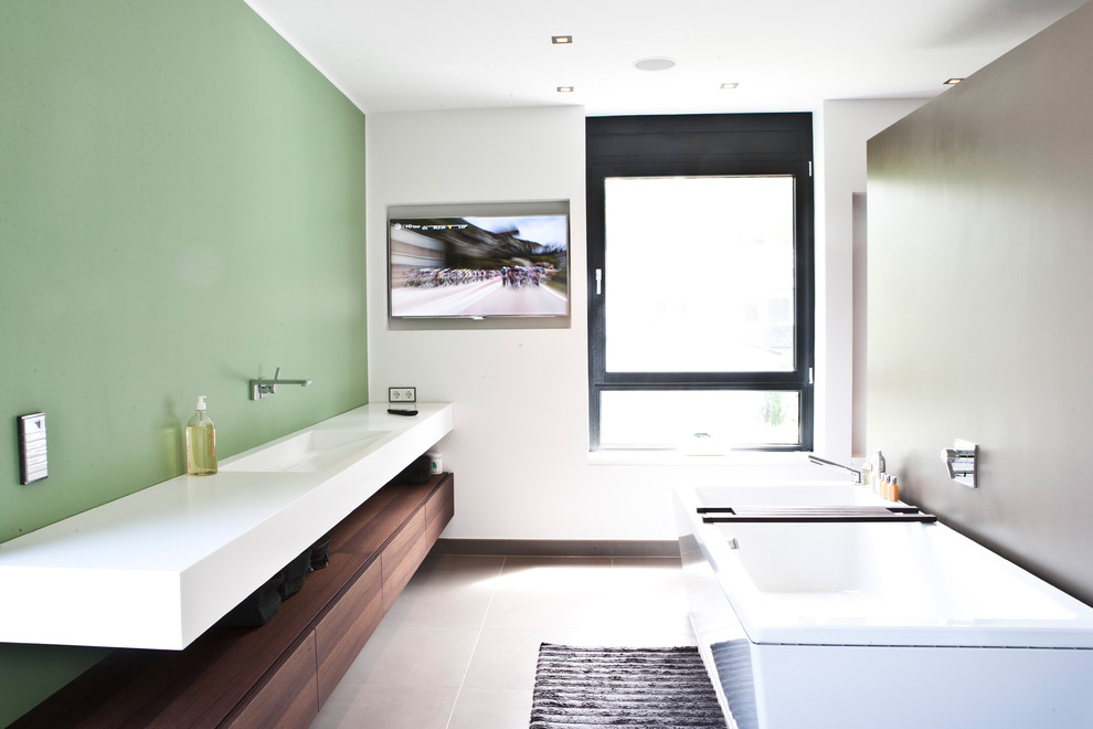 Diseño de cuarto de baño minimalista con puertas de armario marrones, bañera encastrada, paredes blancas, lavabo sobreencimera y encimera de madera