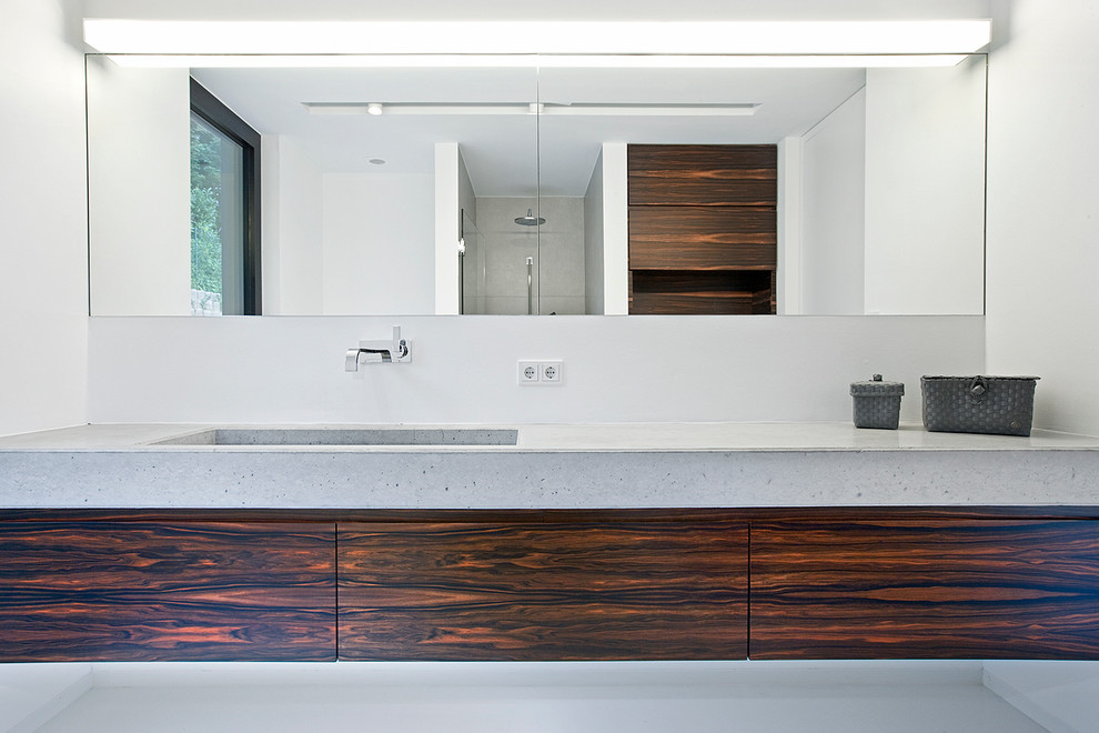 Diseño de cuarto de baño principal contemporáneo de tamaño medio con armarios con paneles lisos, puertas de armario de madera en tonos medios, ducha a ras de suelo, baldosas y/o azulejos grises, paredes blancas y lavabo encastrado