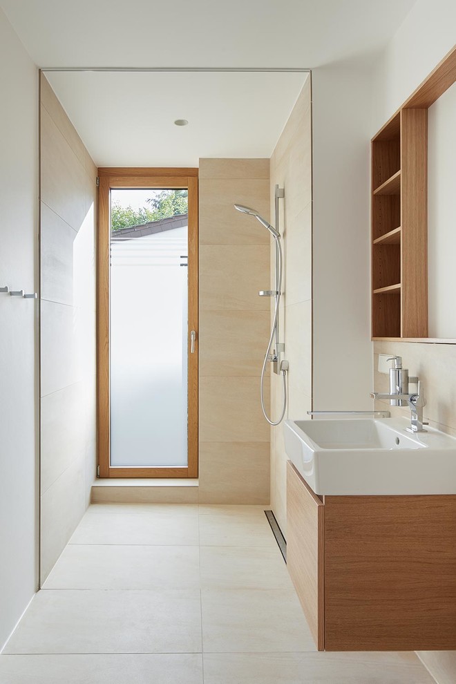Cette photo montre une petite salle de bain moderne avec un placard à porte plane, des portes de placard marrons, une douche à l'italienne, un carrelage beige, un mur blanc, une vasque, un plan de toilette en bois et aucune cabine.