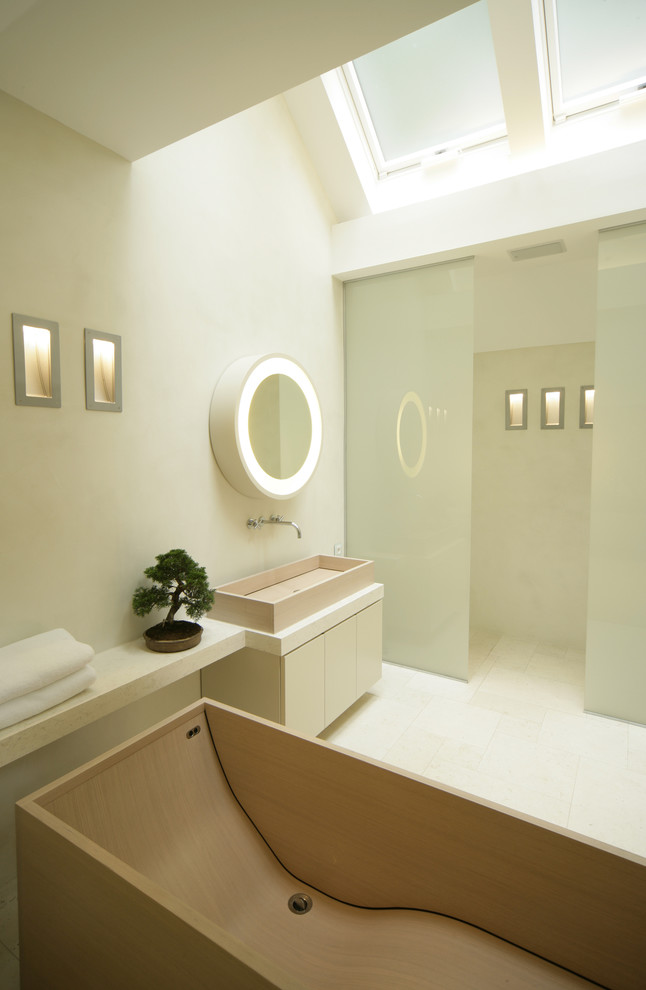 Idée de décoration pour une grande salle de bain design avec un placard à porte plane, des portes de placard blanches, une baignoire indépendante, un mur vert et une vasque.