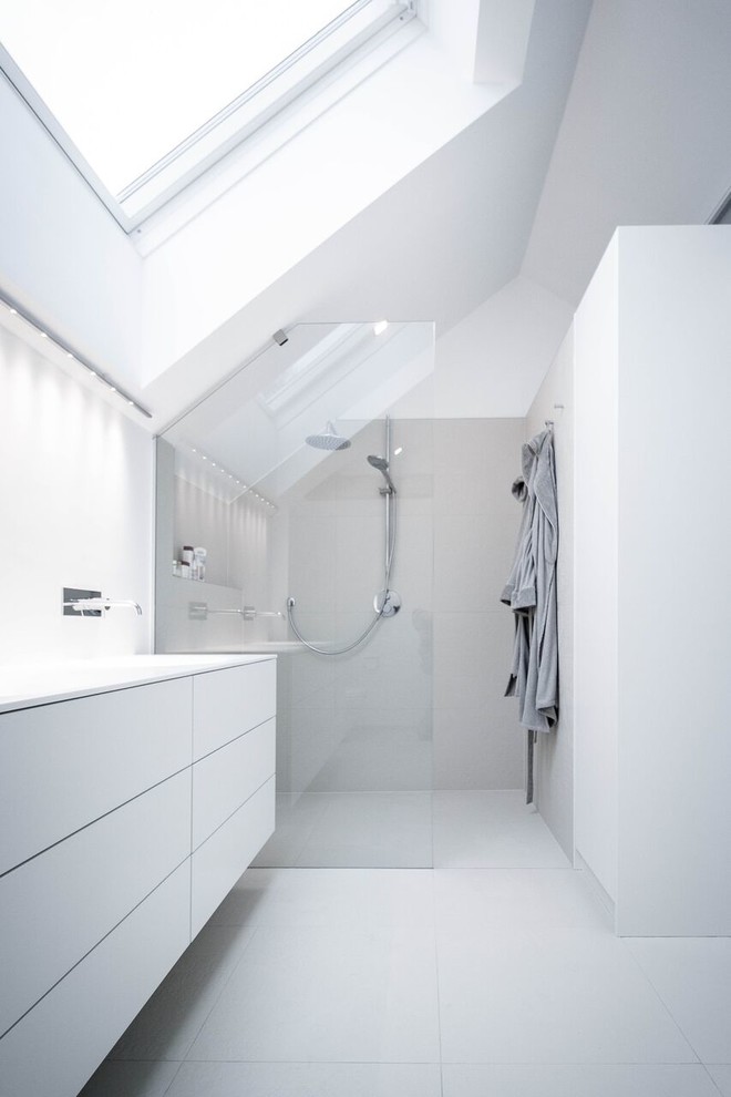 Modelo de cuarto de baño principal moderno de tamaño medio con armarios con paneles lisos, puertas de armario blancas, ducha a ras de suelo, paredes blancas y ducha abierta