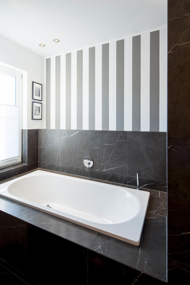 デュッセルドルフにあるトラディショナルスタイルのおしゃれな浴室 (ドロップイン型浴槽、黒いタイル、マルチカラーの壁、大理石の床) の写真
