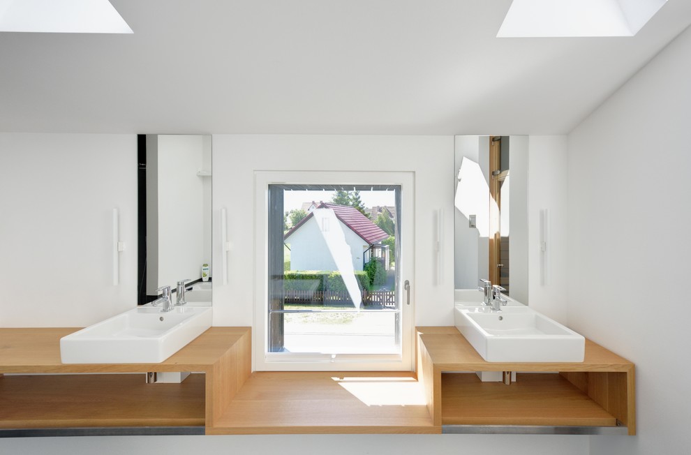 Imagen de cuarto de baño escandinavo con lavabo sobreencimera, paredes blancas y encimera de madera