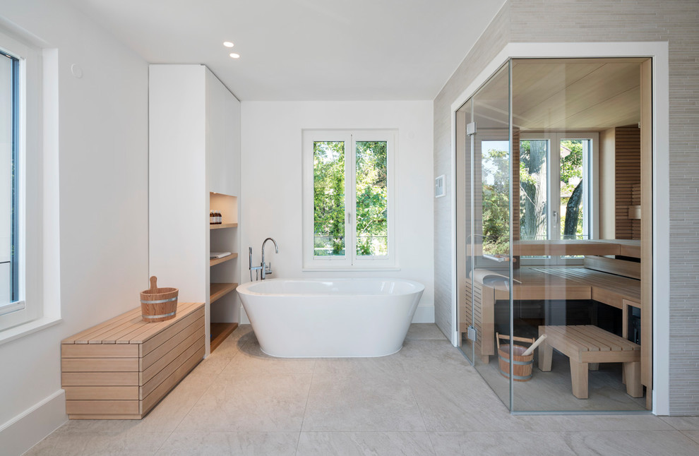 Foto på ett stort funkis bastu, med ett fristående badkar, en dusch/badkar-kombination, vita väggar, cementgolv, beiget golv och med dusch som är öppen