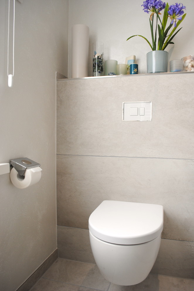 Ispirazione per un bagno di servizio design di medie dimensioni con lavabo rettangolare, WC sospeso e pareti beige