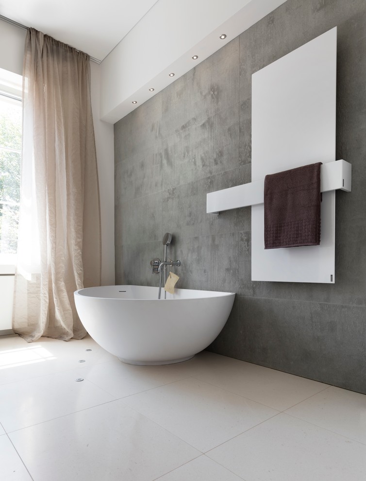 Ispirazione per una stanza da bagno padronale minimalista di medie dimensioni con ante lisce, ante grigie, vasca freestanding, doccia alcova, WC a due pezzi, piastrelle beige, piastrelle di pietra calcarea, pareti bianche, pavimento in pietra calcarea, lavabo sospeso, top in pietra calcarea, pavimento beige, porta doccia scorrevole e top grigio