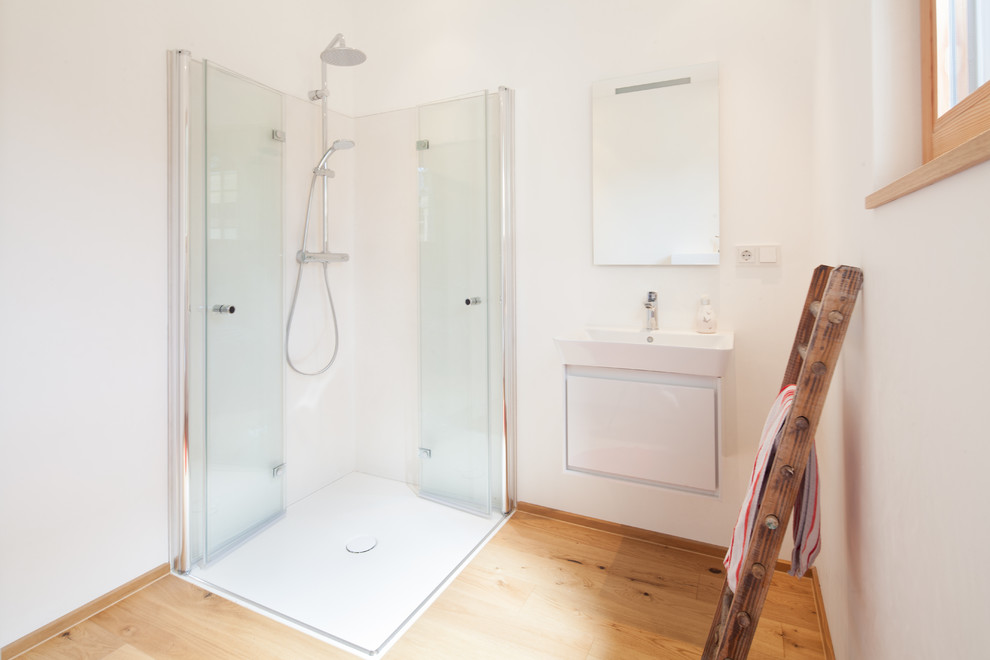 Geräumiges Modernes Badezimmer mit bodengleicher Dusche, weißen Fliesen und Falttür-Duschabtrennung in Essen