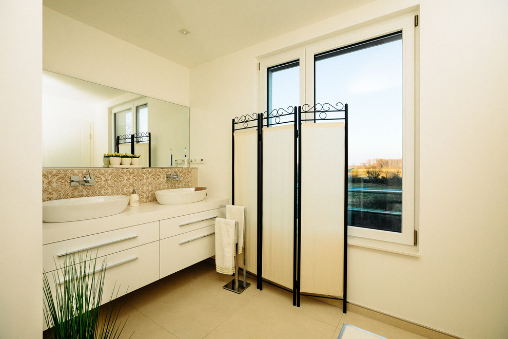 Immagine di una stanza da bagno minimalista con ante lisce, ante bianche, pareti bianche, pavimento con piastrelle di ciottoli, lavabo a bacinella, top in legno, top bianco e mobile bagno sospeso