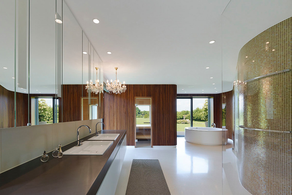 Modern inredning av ett mycket stort bastu, med släta luckor, vita skåp, en kantlös dusch, ett nedsänkt handfat, ett fristående badkar, vitt golv, bruna väggar och med dusch som är öppen