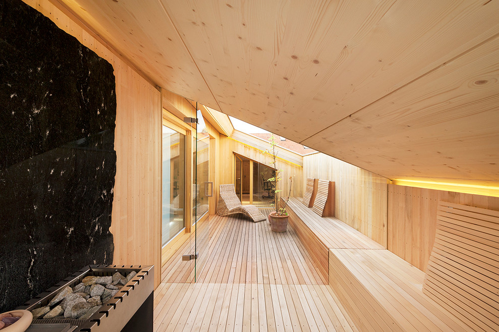 Diseño de sauna actual con paredes marrones y suelo de madera en tonos medios