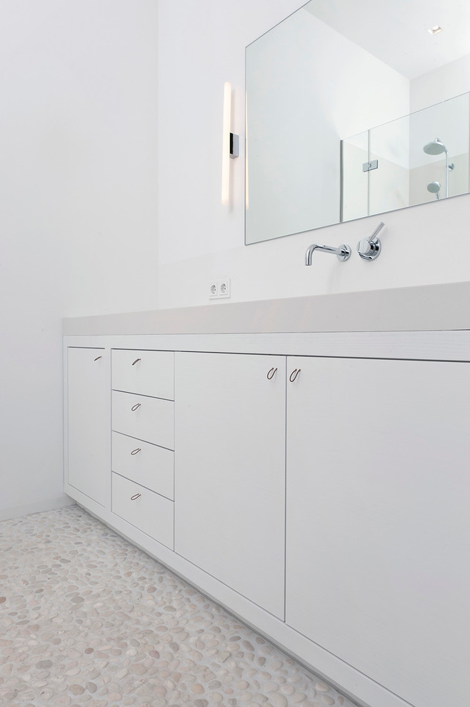 Mittelgroßes Skandinavisches Badezimmer mit flächenbündigen Schrankfronten, weißen Schränken, weißer Wandfarbe und Kiesel-Bodenfliesen in Hamburg