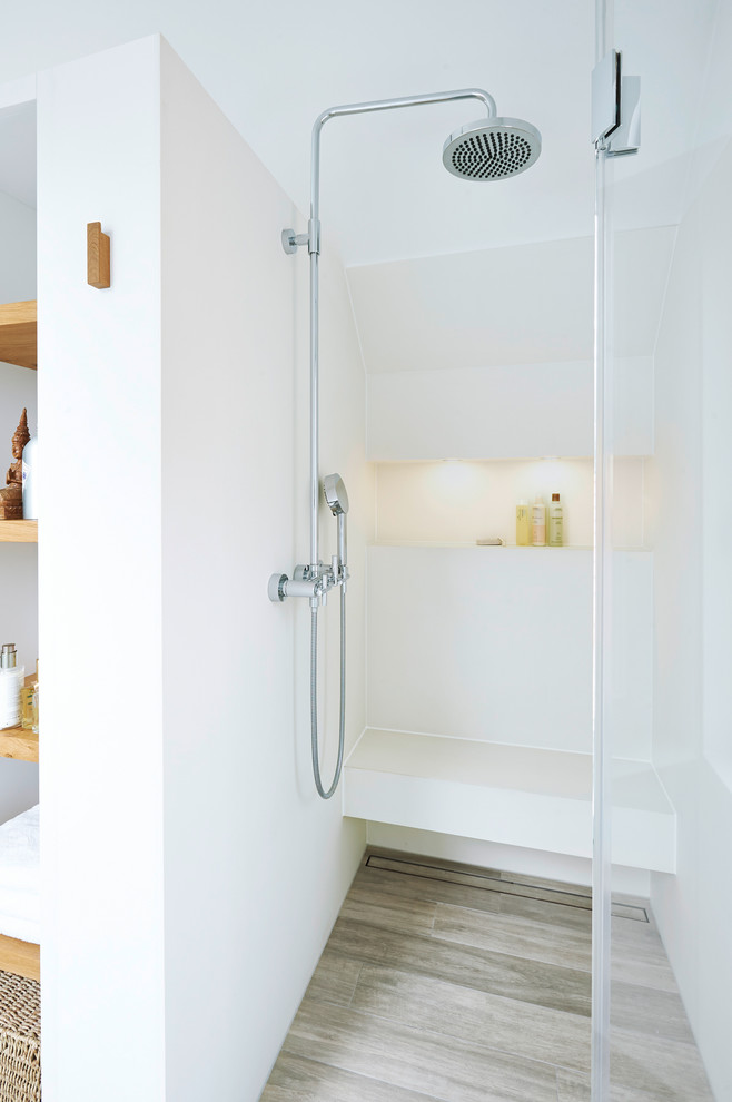 Modernes Badezimmer mit bodengleicher Dusche, weißer Wandfarbe, braunem Holzboden, braunem Boden und Falttür-Duschabtrennung in Hamburg