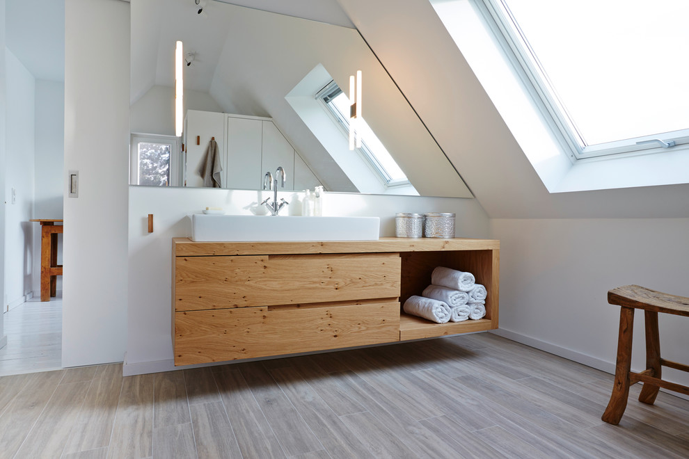 Großes Modernes Badezimmer En Suite mit Aufsatzwaschbecken, hellbraunen Holzschränken, weißer Wandfarbe, hellem Holzboden, offenen Schränken, Waschtisch aus Holz und brauner Waschtischplatte in Hamburg