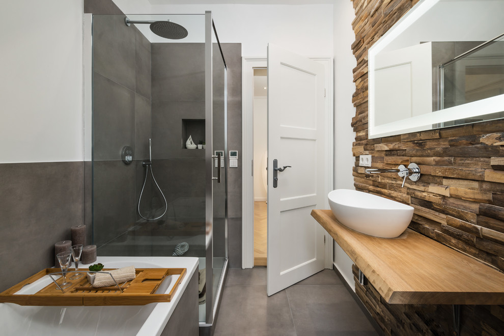 Foto på ett mellanstort funkis beige en-suite badrum, med ett platsbyggt badkar, en hörndusch, brun kakel, grå kakel, vita väggar, ett fristående handfat, träbänkskiva, grått golv och dusch med gångjärnsdörr
