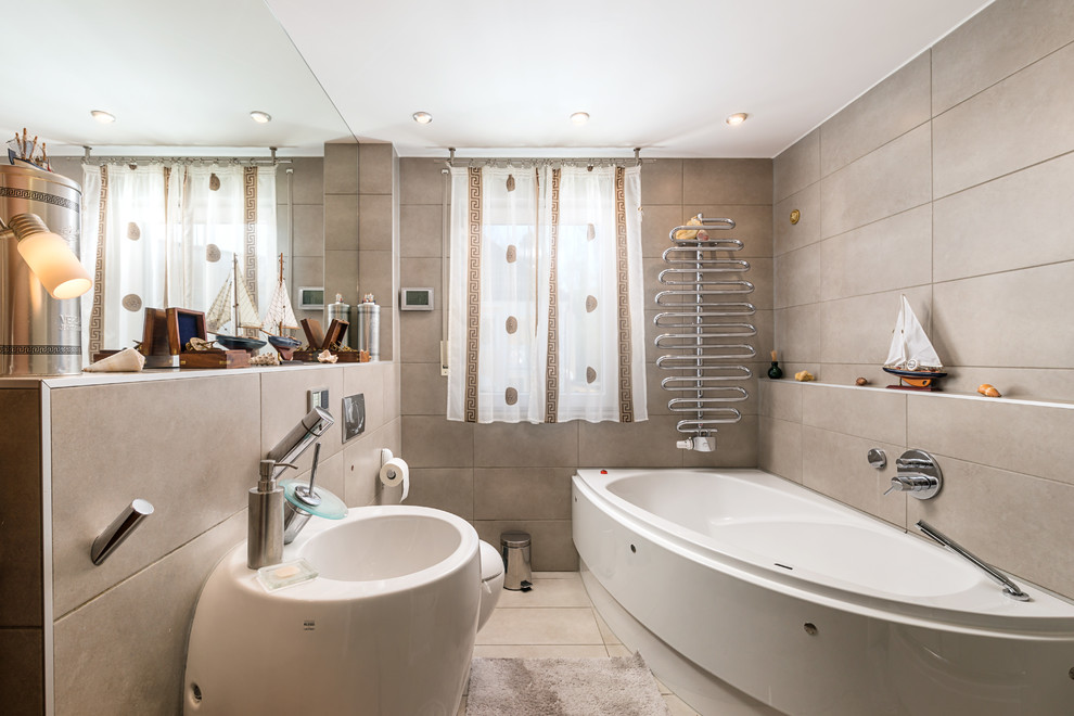 Mittelgroßes Badezimmer En Suite mit Eckbadewanne, Wandtoilette mit Spülkasten, beigen Fliesen, Sockelwaschbecken und beigem Boden in München