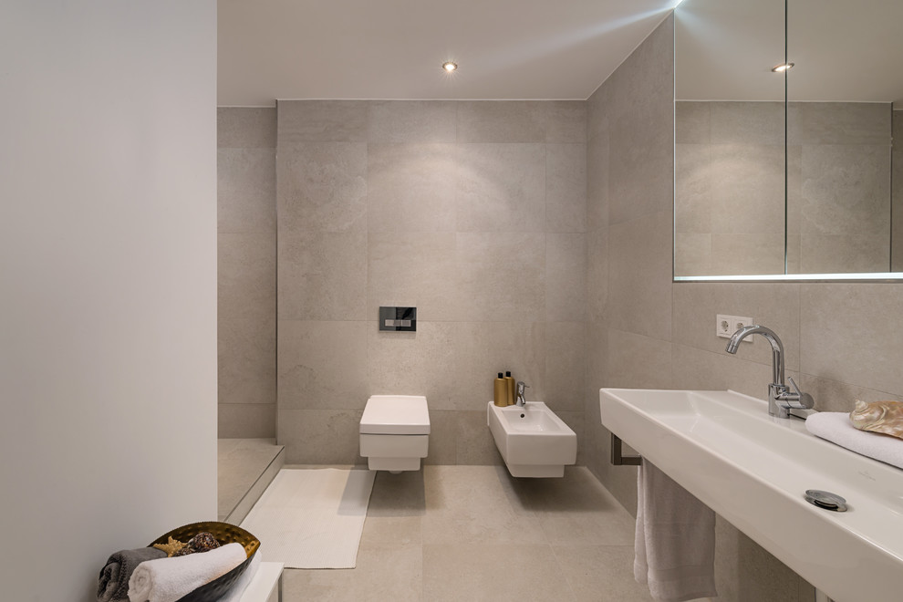 Großes Modernes Badezimmer mit Wandtoilette mit Spülkasten, beigen Fliesen, Zementfliesen, weißer Wandfarbe, Zementfliesen für Boden, Wandwaschbecken und beigem Boden in München