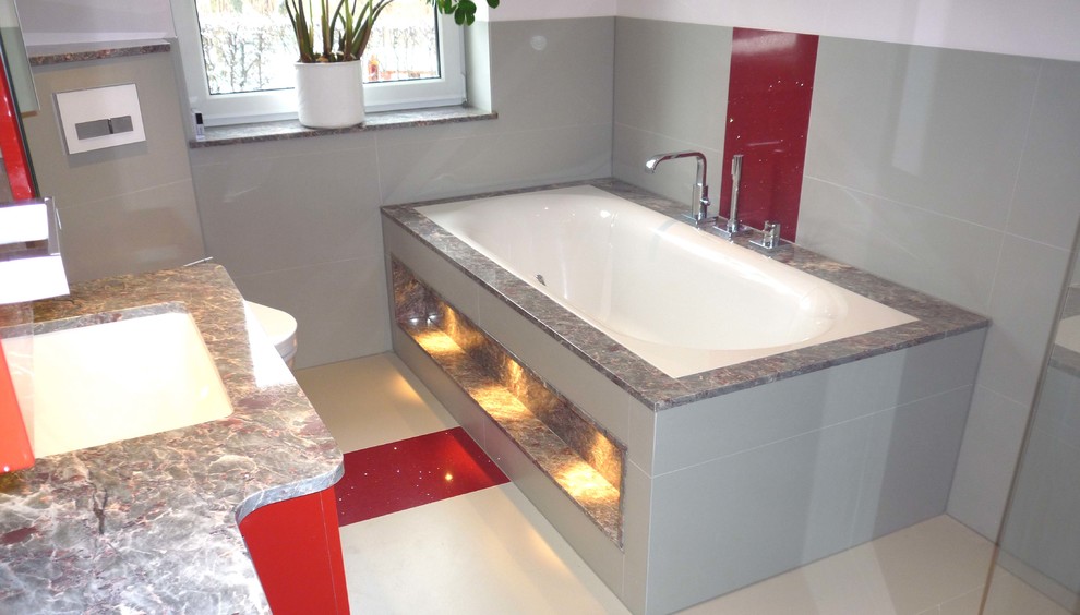 Идея дизайна: ванная комната среднего размера в современном стиле с красными фасадами, накладной ванной, инсталляцией, серой плиткой, плиткой из листового камня, серыми стенами, врезной раковиной и мраморной столешницей