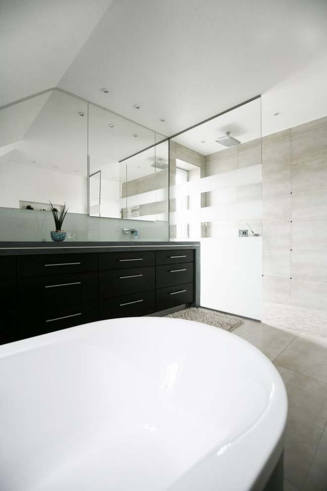 Modern inredning av ett stort grå grått en-suite badrum, med luckor med profilerade fronter, svarta skåp, grå kakel, grå väggar, betonggolv, ett integrerad handfat, bänkskiva i betong och grått golv