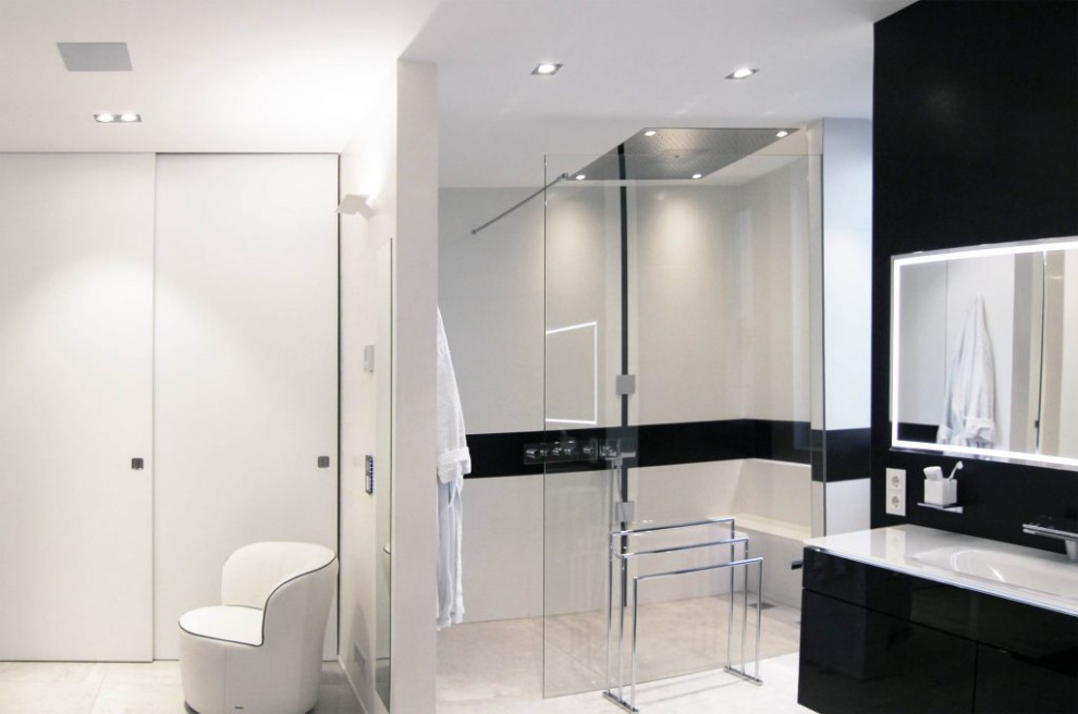 Modern inredning av ett mellanstort svart svart en-suite badrum, med luckor med profilerade fronter, svarta skåp, en vägghängd toalettstol, vita väggar, klinkergolv i porslin, ett integrerad handfat, bänkskiva i akrylsten och vitt golv