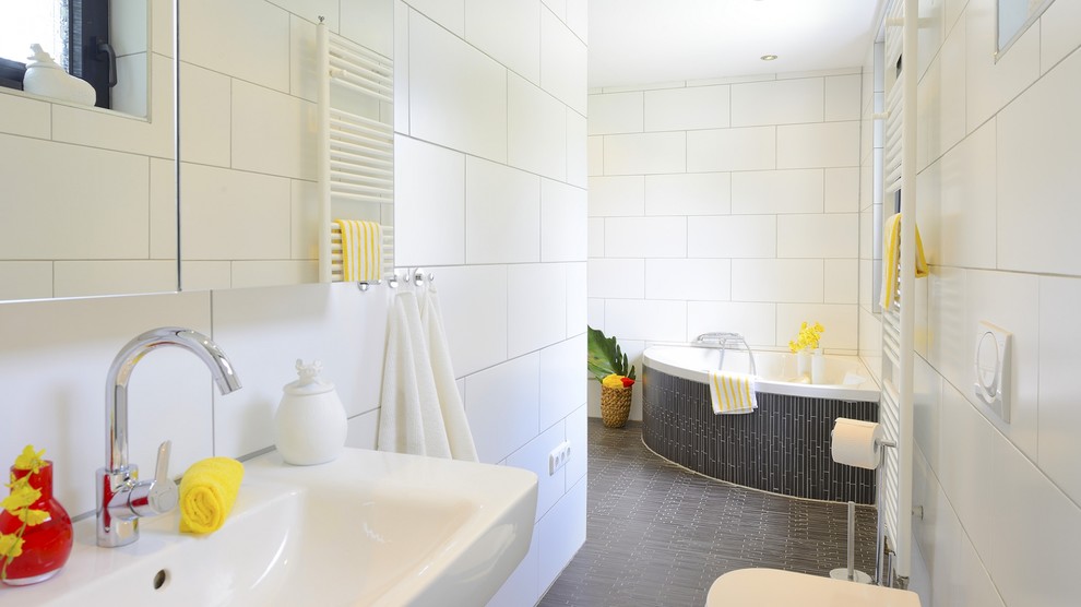 Aménagement d'une salle de bain principale scandinave avec une baignoire d'angle, un carrelage blanc, des carreaux de céramique et un mur blanc.