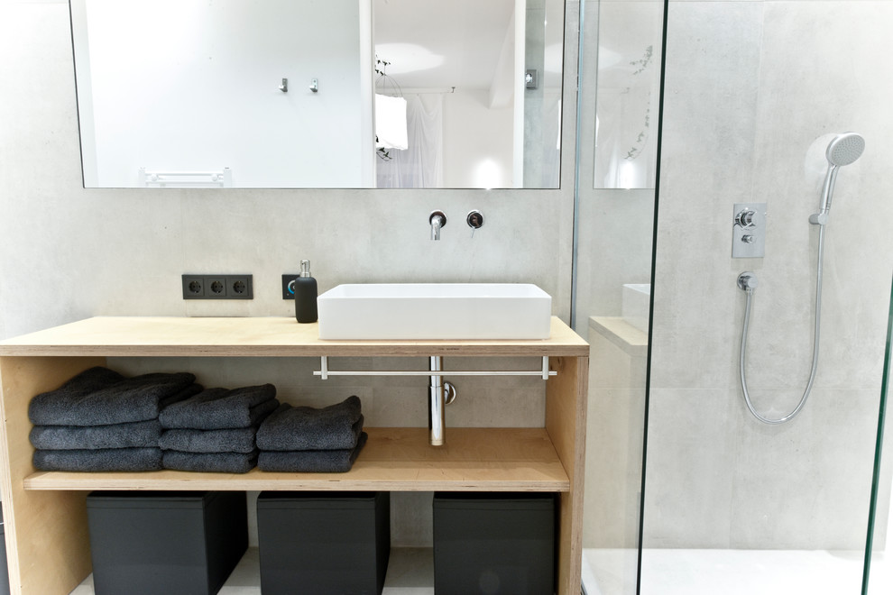 Inspiration for a medium sized urban ensuite bathroom in Munich with open cabinets, a corner shower, grey walls, wooden worktops, a vessel sink, stone tiles and beige worktops.